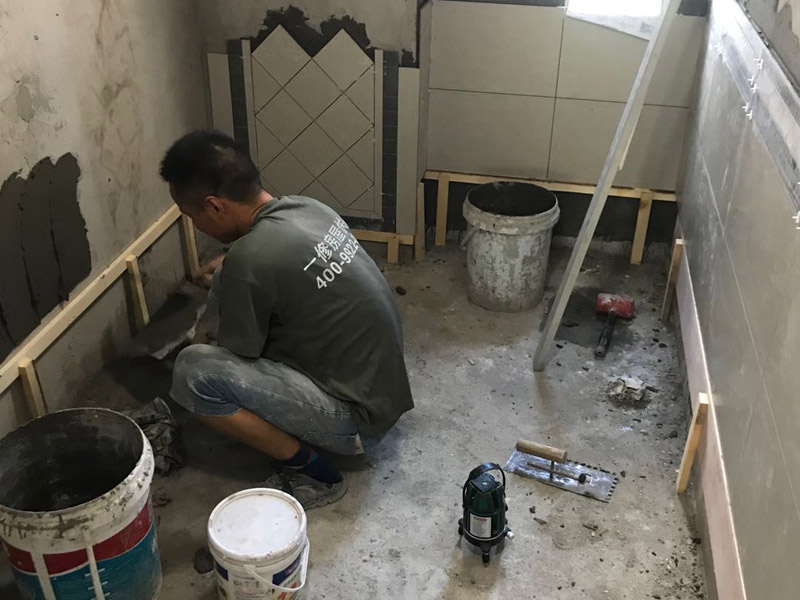 廁所瓷磚鋪貼裝修：首先應(yīng)除去基層表面的污垢，油漬，浮灰;除去基層上所有涂料層，膩?zhàn)訉?如果基層未能達(dá)到平整度要求，需對(duì)基層進(jìn)行預(yù)先的找平處理；鋪貼瓷磚前需事先找好垂直線，以此為基準(zhǔn)鋪貼的瓷磚高低均勻、垂直美觀;將調(diào)制好的漿料均勻地抹在瓷磚背面，要求漿料飽滿；將瓷磚平整地鋪貼在基層上，使用橡膠錘將瓷磚拍實(shí)鋪平。