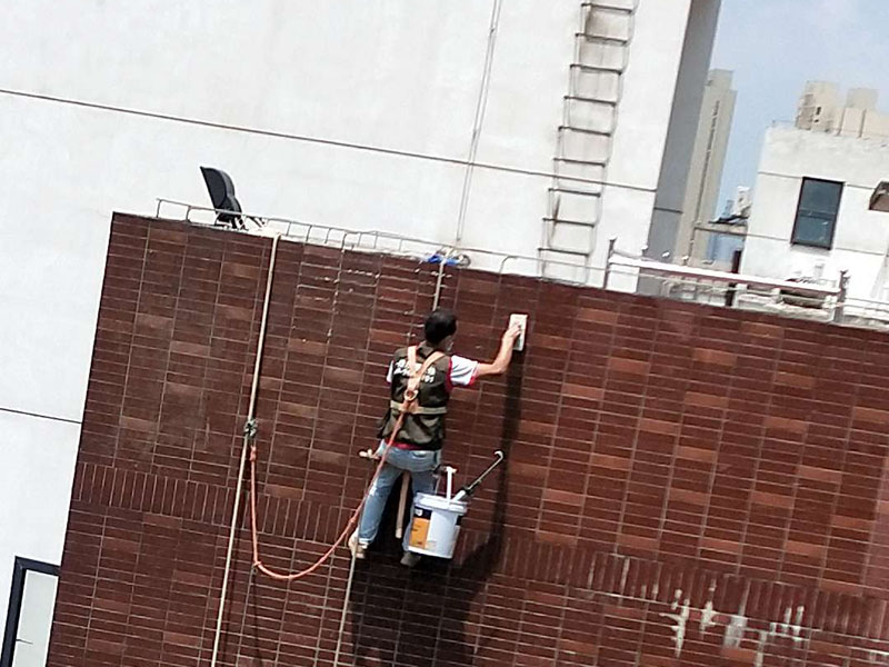 高空外墻防水：外墻面洞和較大裂縫防水密封前用噴水槍等工具將待治理的外墻面、伸縮縫、窗框等部位清理干凈，使施工的外墻面及縫、孔、洞部位達(dá)到無油、無塵土、無水泥松散顆粒等雜物。   待其干燥后，將孔、洞、縫用防水密封材料嵌填密實(shí)，并達(dá)到與原顏色一致，再用快速堵漏靈和透明防水膠膜進(jìn)行精心施工。整體條形瓷磚外墻面防水，采用高效環(huán)保型憎水進(jìn)行精心施工。該材料具有防水性能優(yōu)異、透氣性能良好、施工方便、使用安全、質(zhì)量可靠、耐久性好等特點(diǎn)。