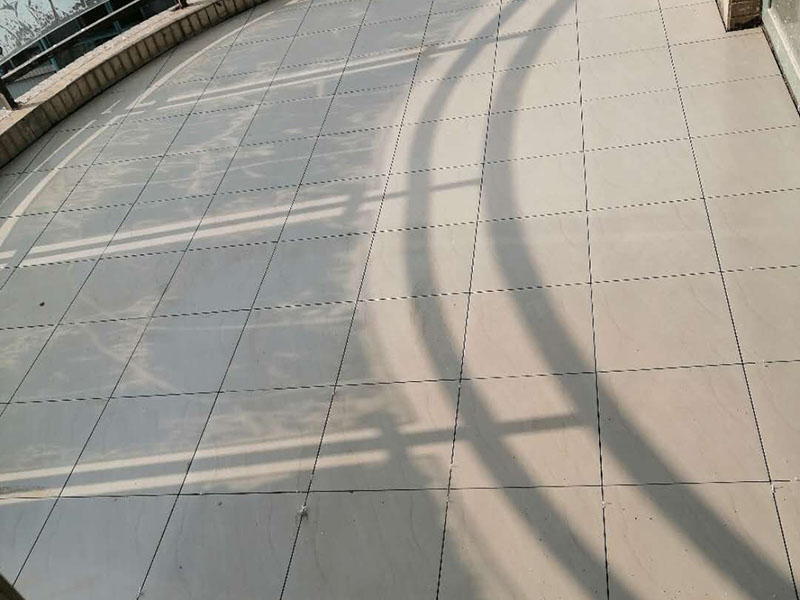 陽臺瓷磚拆除重鋪：準備粘結劑前，瓷磚不應浸水，但要用鋼絲刷除去磚背面的松散物質，并用濕布抹去磚背的浮塵。然后按照生產商建議的比例將水或乳液放到攪拌桶中攪拌直至粘結劑均勻無結塊。 在鋪壓瓷磚前，在瓷磚背面也批一薄層粘結劑。這種雙批法雖然用的材料和工時比較多，但卻能夠保證粘貼的質量和耐久性。 在粘結劑量置晾時間內，將準備好的瓷磚鋪壓到位，垂直于梳理方向輕微搓動以排出磚下的空氣。鋪貼到位后用橡皮錘輕擊，用尺寸合適的十字定位架來調整表面平整度及接縫的平直。 鋪設好的磚面應該及時清理干凈，特別是去除殘留其上的粘結劑。合格的粘結劑干硬后即使在陶瓷磚面上也不易被清除掉。清理好的瓷磚面應該立即擺放標識進行隔離，避免污染或擾動，直到下一個填縫工序。