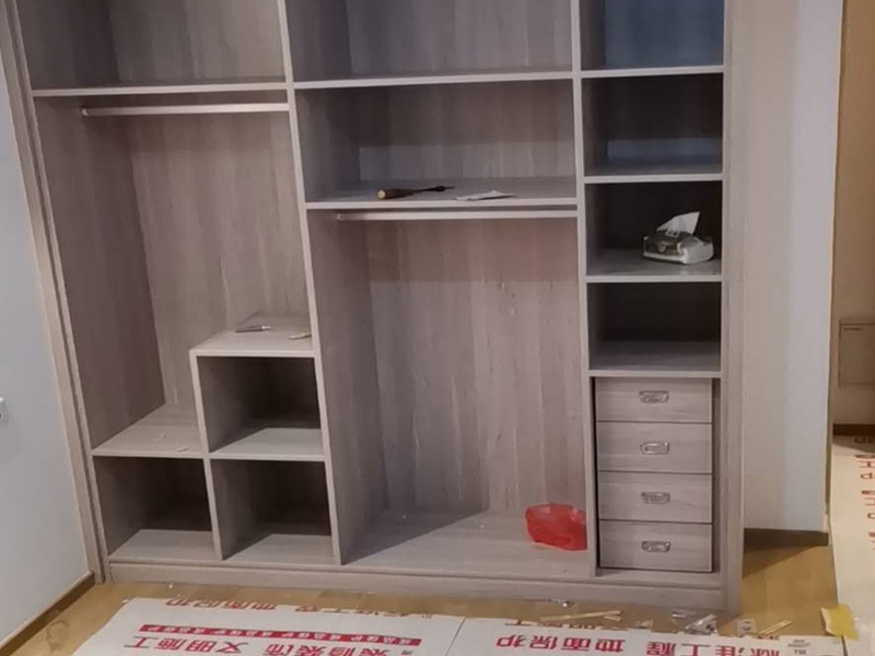 家具柜體安裝：用墊布點好地板，先從靠墻的一端寬du側(cè)板開始組裝，將寬側(cè)板平放于地面上(離后墻面保持700mm間隔)。首先將填好的三合一膠塞的板件，平放在墊布上，檢查孔距與圖紙相符，并裝上三合一單連桿。然后將固層釘上木塞，固定于寬側(cè)板上面，頂板大柄孔朝上，其余固層都朝下，腳線大柄孔朝內(nèi)(中間固層與L架高度一致，即底板到固層內(nèi)空為960mm，現(xiàn)場打?qū)影蹇?。放上側(cè)板，釘上木塞，木塞要求連通兩邊的固層。在第二個柜固層上面裝好雙連桿，留意雙連桿上面大柄只能鎖住一半，即90°。當兩件固層與側(cè)板固定后再同時擰緊大柄。 釘背板：把裝好的整體柜側(cè)放在點好墊布的地板上面，墊平側(cè)板成統(tǒng)一平面。用拉尺量好柜子的對角尺寸，調(diào)至相等，從寬測板處開始裝第一塊背板，留意假如中間有固層釘釘子時，先用鉛筆畫好固層的中央線，再釘釘子。