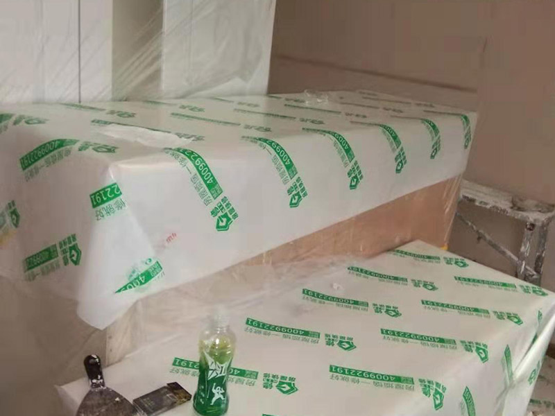 全屋家具成品保護(hù)：滿鋪成品瓦楞紙板，再用干凈彩條布滿鋪在普通石膏板上，在彩條布交接處及轉(zhuǎn)角處用膠帶固定，也可選用木芯板或三夾板。材料選用視上人、車情況而定。 所有成品飾面板在安裝好后必須用PE保護(hù)膜覆蓋包起來(lái)，所有成品飾面板的陽(yáng)角位必須用硬質(zhì)紙護(hù)角或泡沫棉進(jìn)行保護(hù)性包裝，防止交被其他施工人員碰撞。 1、入戶門扇用公司統(tǒng)一的門貼進(jìn)行全面包裹保護(hù)，用透明膠帶將保護(hù)膜粘貼牢固平整。 2、用標(biāo)準(zhǔn)保護(hù)膜將門框三面保護(hù)完整并固定牢固。 3、工程完工后拆除保護(hù)膜時(shí)如果有粘貼時(shí)的膠痕，應(yīng)用酒精或?qū)Ｓ玫那逦蹌┣宄z痕。