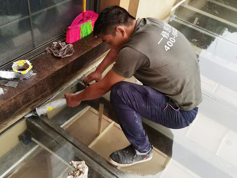 屋頂防水打膠案例：不少建筑新建成就滲漏，老建筑的滲漏現(xiàn)象更嚴(yán)重。第一步：把玻璃的邊清理干凈。把玻璃固定到位。在玻璃邊緣3mm處貼美文紙。第二步：用結(jié)構(gòu)膠往縫里填到60％。第三步：用和縫大小的泡抹棒往里壓填充，把膠往玻璃與型材的縫里擠。第四步：填充耐候密封膠，用刮刀來回30度角度刮2遍。缺膠的補(bǔ)上。30分內(nèi)把紙揭掉。