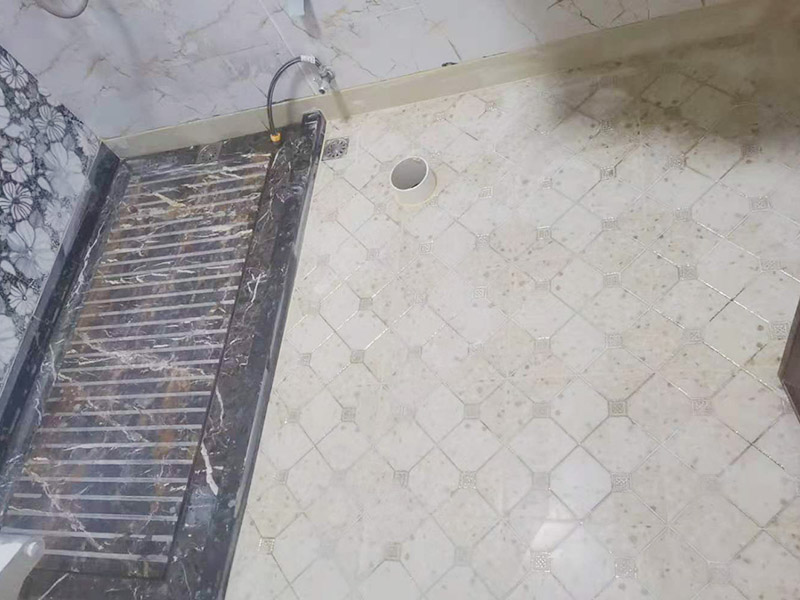 衛(wèi)生間地面防水裝修:首先要將墻面地面都要清潔干凈，這點(diǎn)非常重要，不能有散沙、土、石塊等干擾基層。如果基層開發(fā)商做的很不好的話，表面還要刷一層界面劑以防止墻面表面起沙。用噴壺將陰角部分和管根部分噴水，噴水的主要目的就是防止墻面吸收了堵漏寶太多的水分，造成堵漏寶沒有和墻面凝結(jié)在一起。那么噴多少水呢，建議以表面沒有明顯積水為宜。刷完以后，由于速凝型的堵漏寶干燥較快，所以基本不用等待，干的非常快。然后將第一遍堵漏寶上鋪好網(wǎng)格布，主要是防止堵漏寶初凝以后裂開。然后進(jìn)行第二遍涂刷堵漏寶，刷完咱們就要進(jìn)行下面柔韌性防水涂刷的步驟了。