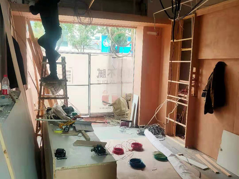 門(mén)店木工施工現(xiàn)場(chǎng):首先應(yīng)該搭建木作施工臺(tái)。木作施工臺(tái)用于板材的切割板，板材的造型，板材的平整度處理等等。門(mén)窗的制作包括門(mén)窗套制作、門(mén)窗制作。要特別注意門(mén)窗扇與框之間的縫隙不能太大，以及門(mén)窗套與門(mén)窗的色差等。木作表層封裝木制品制作完成后，對(duì)其表面進(jìn)行細(xì)節(jié)封裝。木作表層封裝通常就要用到各種各樣的家裝板材，特別注意板材的選購(gòu)。