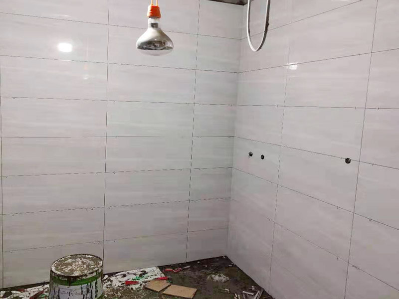 浴室貼磚裝修:把還沒(méi)有涂抹水泥的地磚鋪在地上，把它們敲平，然后在地磚上涂滿水泥，鋪在地面，保持四塊磚的對(duì)角位置對(duì)齊。 鋪瓷磚的順序其實(shí)也是有不少講究的，鋪地磚的時(shí)候應(yīng)該從內(nèi)向外貼，遇到坡度或者有地漏的地方，還要注意排水方向找坡；墻面磚的鋪貼應(yīng)該從下向上進(jìn)行。為了最后的鋪貼效果美觀，最底層的瓷磚要最后貼；墻面磚鋪貼結(jié)束以后還要壓地磚。 這里要注意的是，貼瓷磚的時(shí)候不能一面墻貼到頂，否則由于瓷磚較重容易引起脫落。鋪好了地磚盡量不要去踩。 因?yàn)榇纱u本身有許多小孔，吸水能力強(qiáng)，干燥的瓷磚會(huì)吸干水泥的水分.