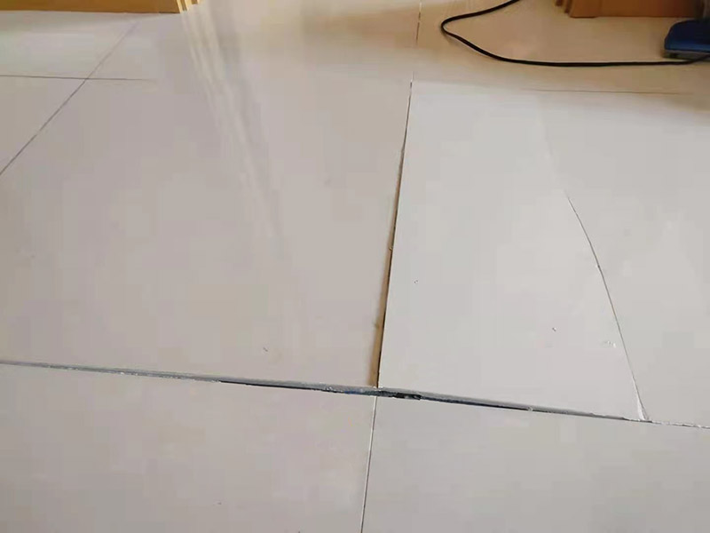 客廳地磚起翹修復：將油灰刀的邊緣滑入松散的瓷磚與其旁邊的瓷磚之間的接縫中。撬起瓷磚并將其移除。用金屬刮刀或小的撬桿的平坦邊緣刮掉基材和瓷磚背面的稀釋劑或瓷磚粘合劑。用相同的工具刮擦周圍空間的舊水泥漿。用清水沖洗除去翹起的瓷磚，然后用濕海綿擦拭，使其干凈。將砂漿抹在缺口邊緣上，然后將稀釋水泥砂漿抹在瓷磚的背面，將瓷磚鋪回原位。如果難以將瓷磚平整，則將瓷磚墊片插入接縫或修補物與包圍它的瓷磚之間的接縫或接縫中。刮掉多余的漿液，并讓該區(qū)域靜置約10分鐘。用水蘸軟海綿，然后輕輕擦拭修復區(qū)域。瓷磚上出現(xiàn)一層干粉后，請用干抹布擦拭。